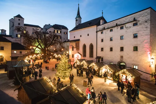 Christmas market in a historic European courtyard with festive lights and decorated stalls